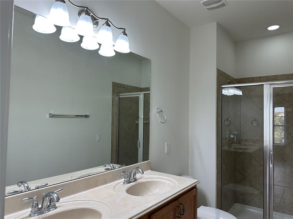 7668 Billingham Street Windermere, FL 34786 - Photo 7 of 15 a bathroom with a sink vanity mirror and toilet