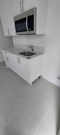 a utility room with a sink and microwave