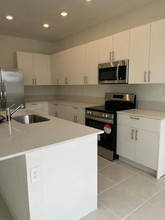 a kitchen with a sink a stove and cabinets