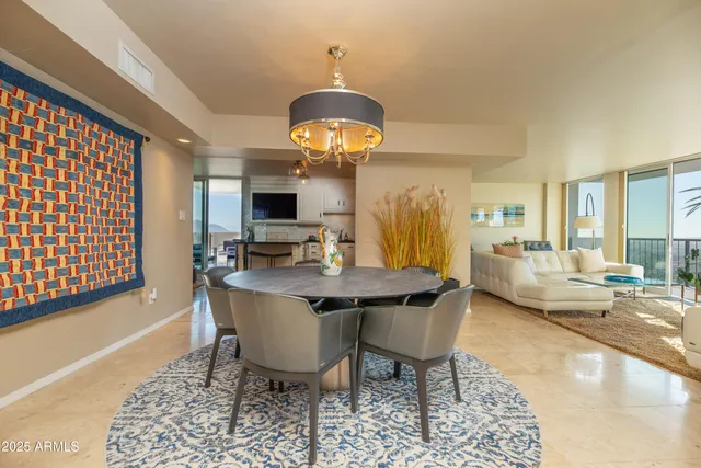 a dining room with wooden floor a chandelier a wooden table and chairs
