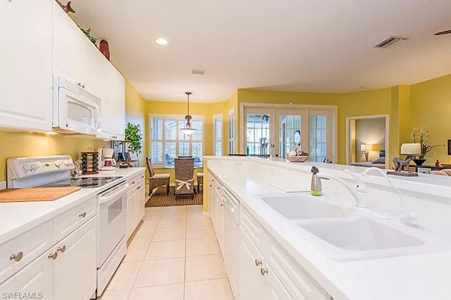 a large white kitchen with a large window