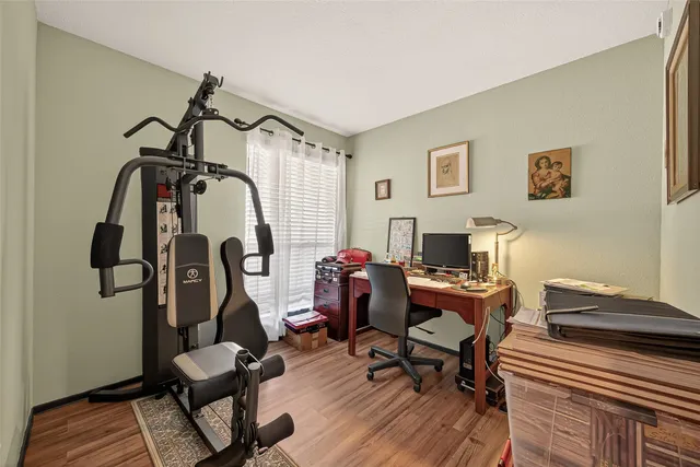 a view of a workspace with furniture and gym equipment