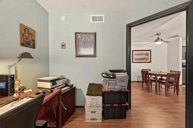a view of a workspace with furniture and wooden floor