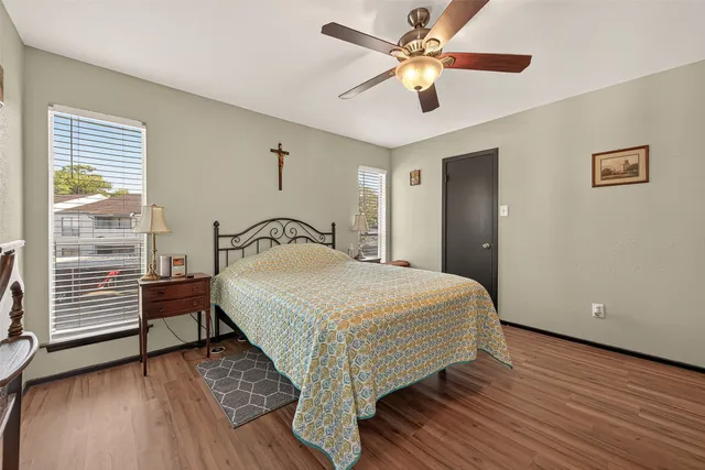 a bedroom with a bed and a large window with wooden floor