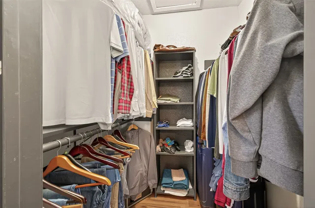 a view of walk in closet with clothes and shoes