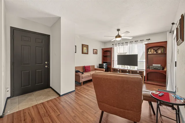a living room with furniture a flat screen tv and kitchen view