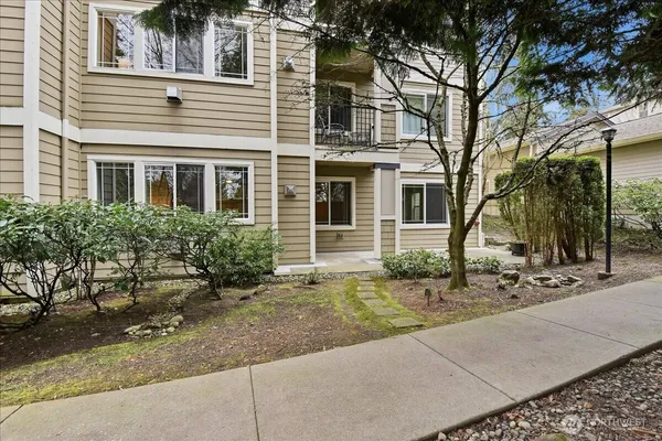 a front view of a house with a yard and potted plants