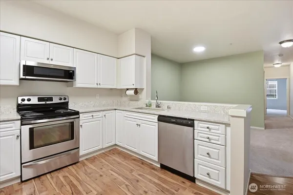 a kitchen with stainless steel appliances granite countertop a stove and cabinets