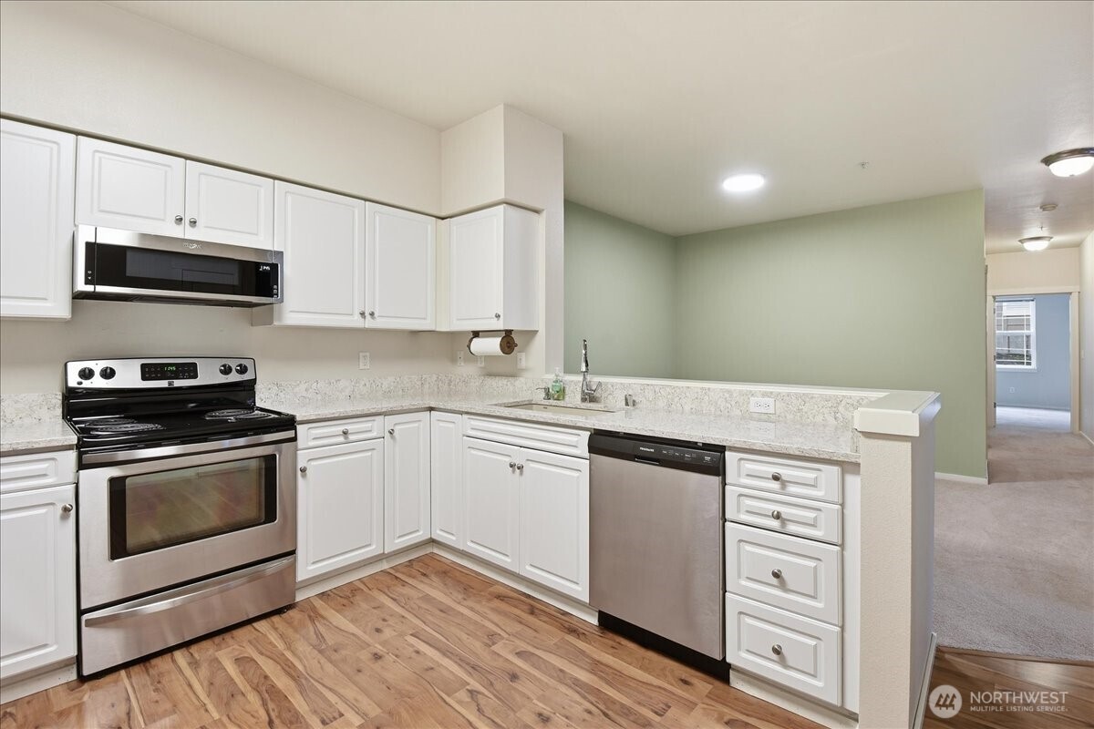 107 164th Street Southeast, Unit 2103 Bothell, WA 98012 - Photo 6 of 24 a kitchen with stainless steel appliances granite countertop a stove and cabinets