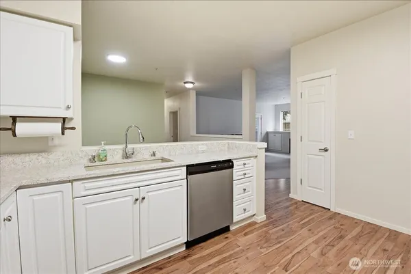 a kitchen with a sink cabinets and wooden floor