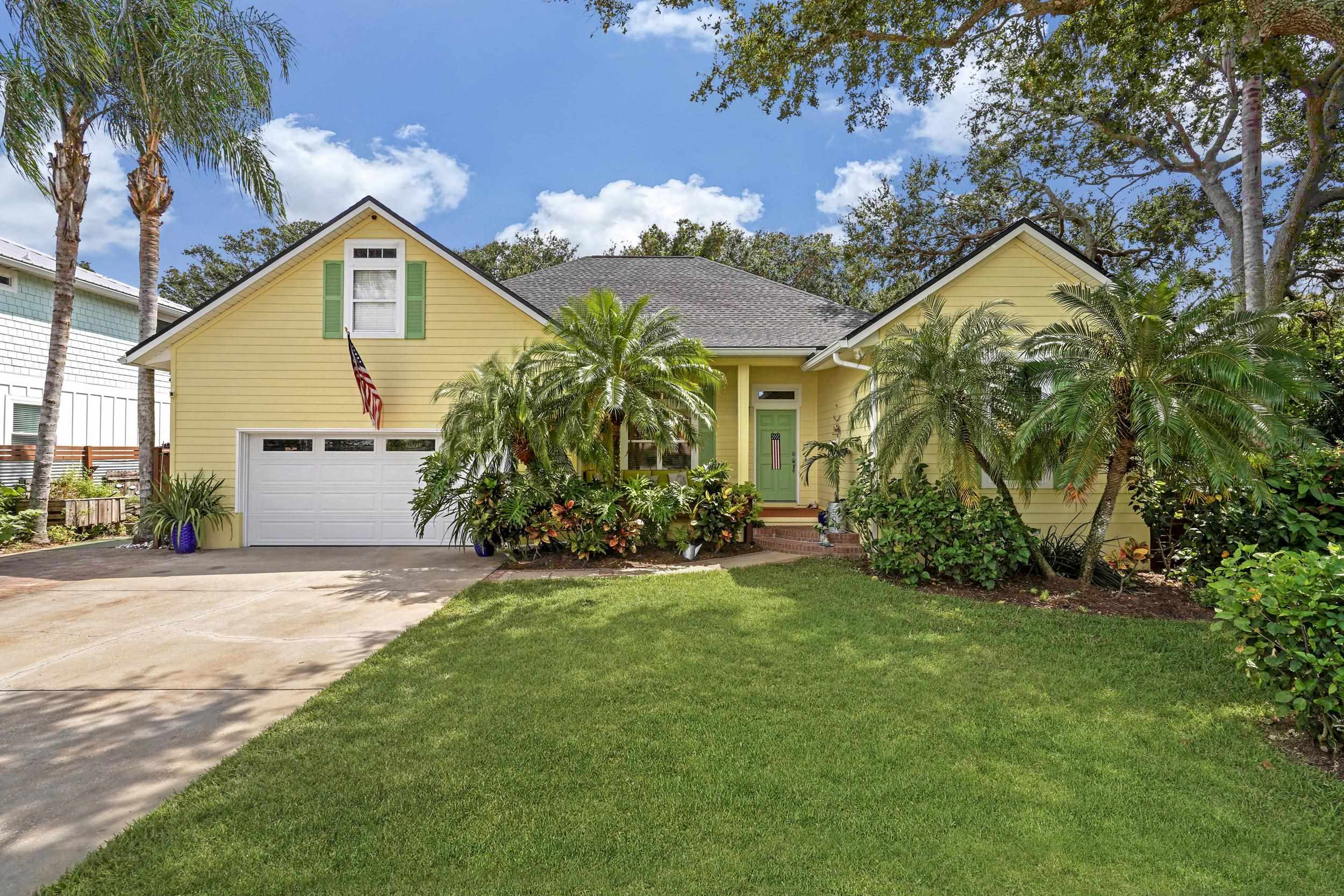 a view of a house with a big yard and large trees