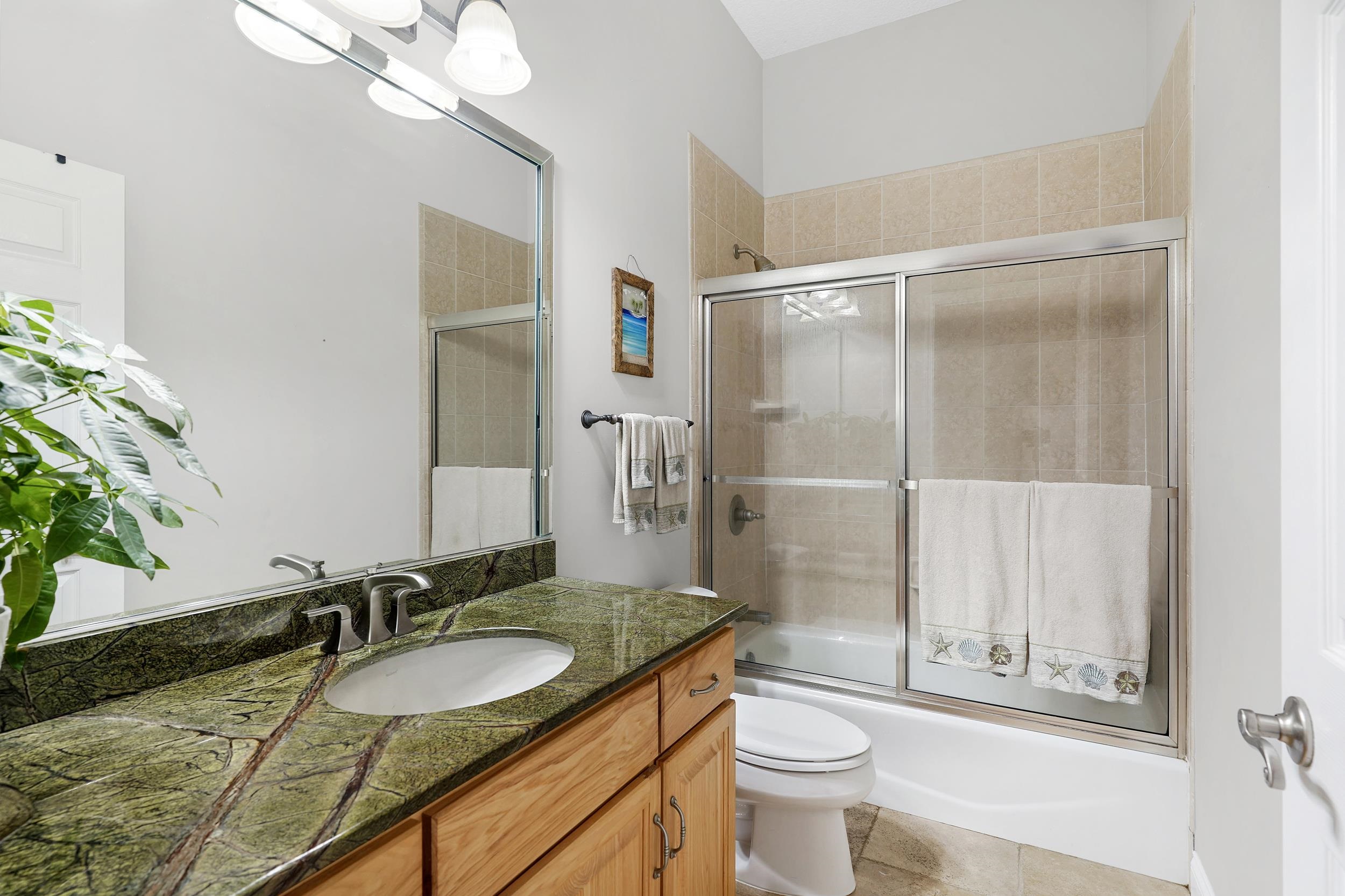 509 Twentieth Street St. Augustine, FL 32084 - Photo 28 of 40 a bathroom with a granite countertop sink toilet and shower