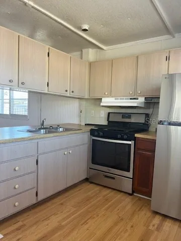 a view of a room with wooden floor and windows