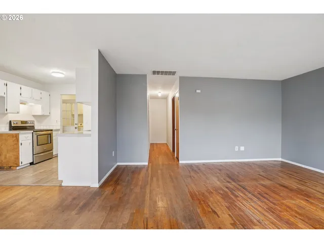 a view of an empty room with wooden floor