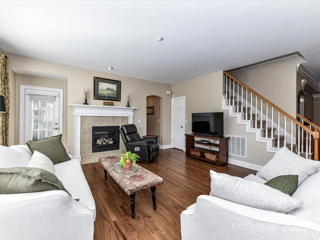 a living room with furniture a flat screen tv and a fireplace