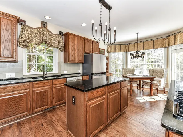 a kitchen with stainless steel appliances granite countertop counter space a sink cabinets and wooden floor