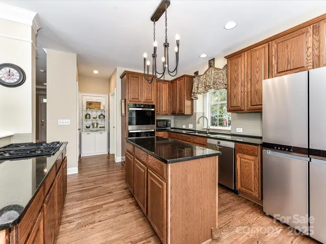 a kitchen with granite countertop a stove oven and refrigerator