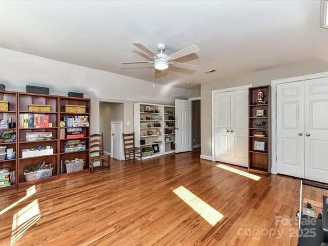 an empty room with bookshelf and wooden floor