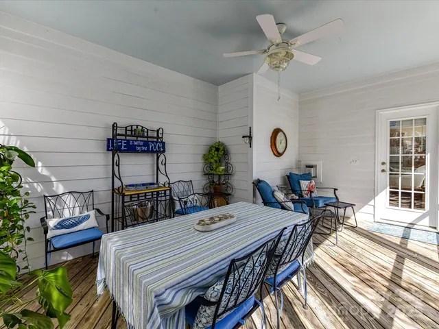 a view of a dining room and livingroom with furniture wooden floor a rug a potted plant and a chandelier