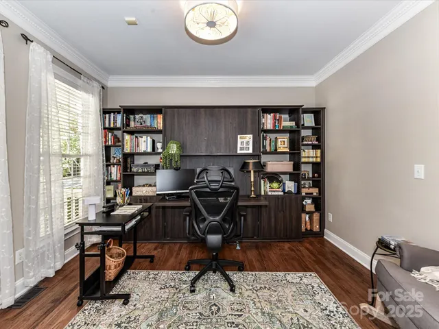 a view of a workspace with furniture and a window