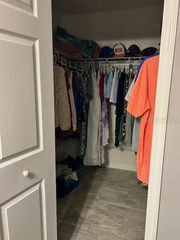 a view of walk in closet with clothes