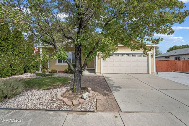 a front view of a house with a yard and trees