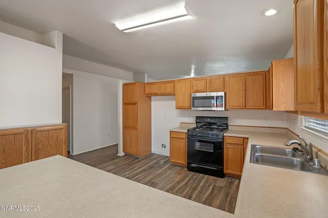 a kitchen with stainless steel appliances granite countertop a stove a sink and a refrigerator