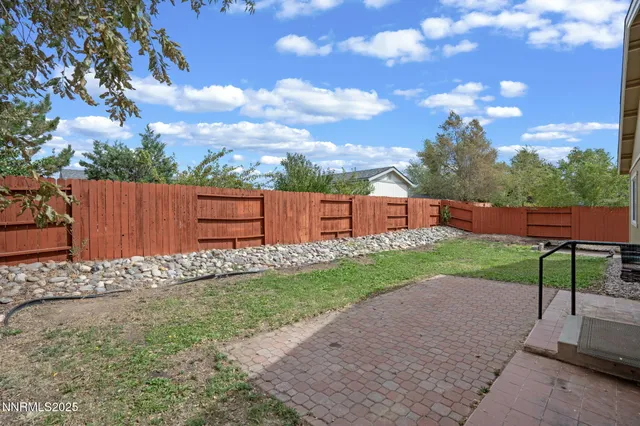 a backyard of a house with table and chairs