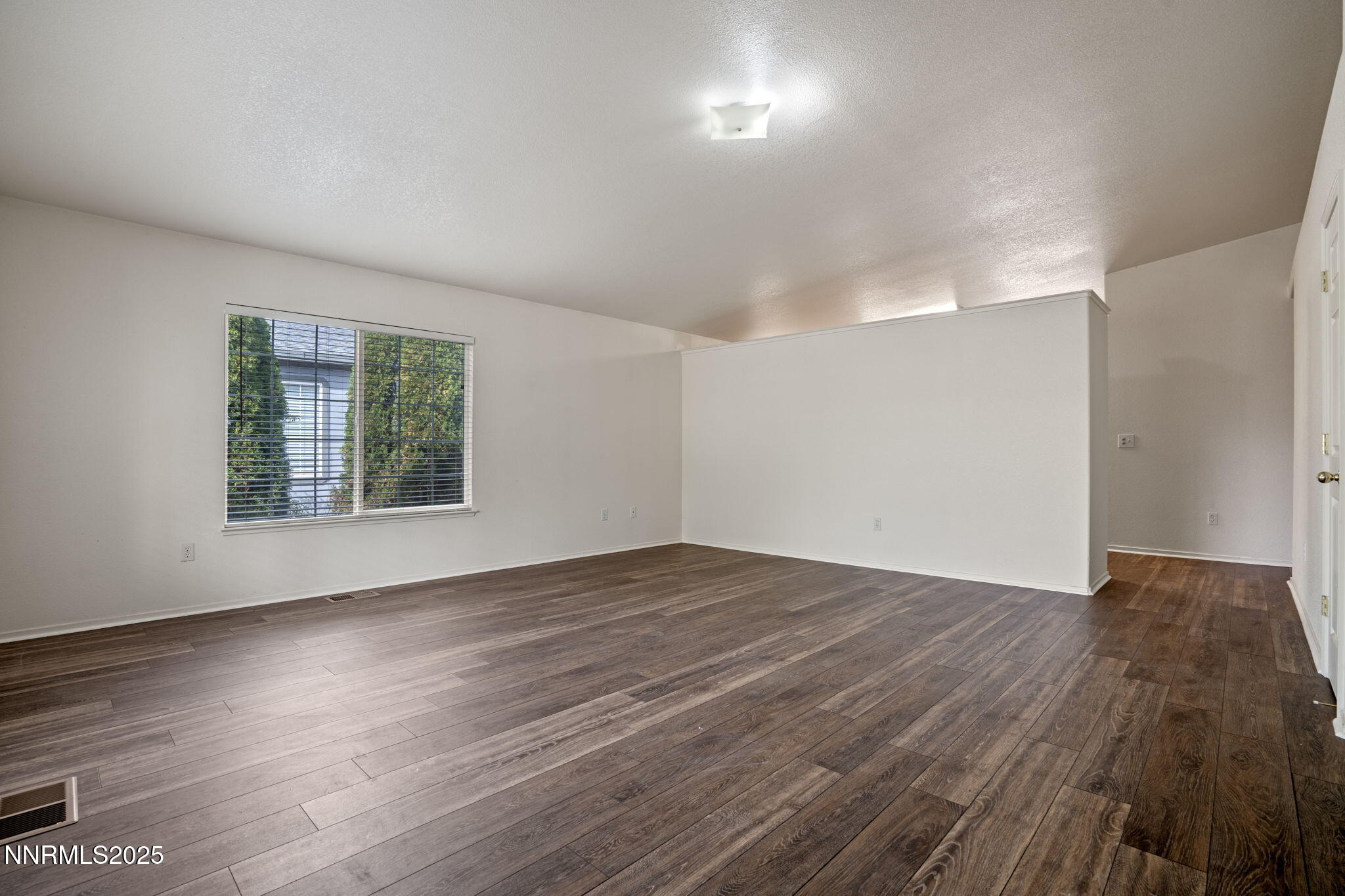 18197 Almondleaf Court Reno, NV 89508 - Photo 9 of 34 a view of an empty room with wooden floor and a window