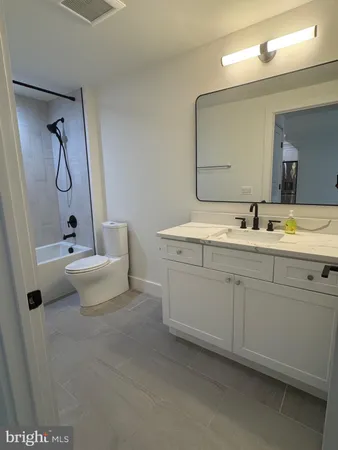 a bathroom with a double vanity sink mirror and toilet