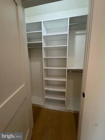 a view of walk in closet with empty racks