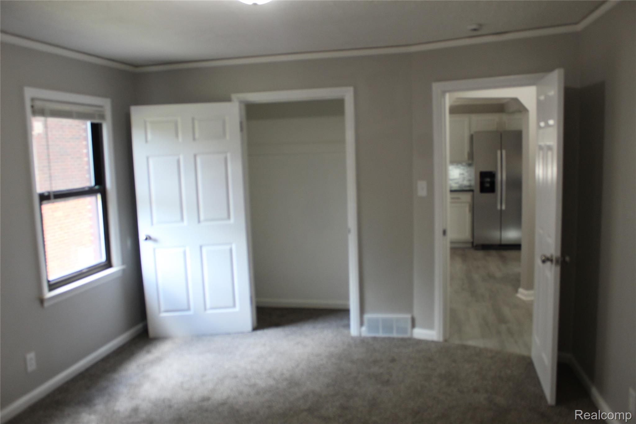 5543 Balfour Road Detroit, MI 48224 - Photo 17 of 54 Carpeted interior space featuring light grey walls, white trim, and a window with blinds