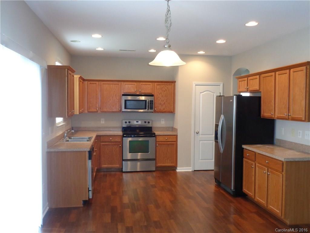 6517 Del Rio Road Charlotte, NC 28277 - Photo 5 of 15 a kitchen with stainless steel appliances granite countertop a refrigerator a stove top oven a sink and dishwasher with wooden floor