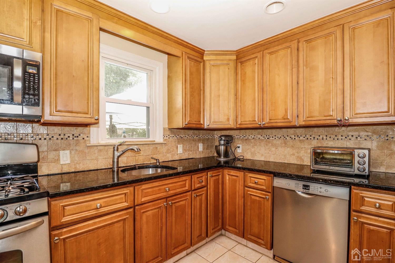 166 Brower Avenue Edison, NJ 08837 - Photo 17 of 48 a kitchen with stainless steel appliances granite countertop a sink a stove and a refrigerator