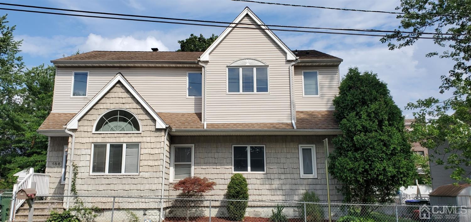166 Brower Avenue Edison, NJ 08837 - Photo 3 of 48 a view of a brick house with large windows and a small yard