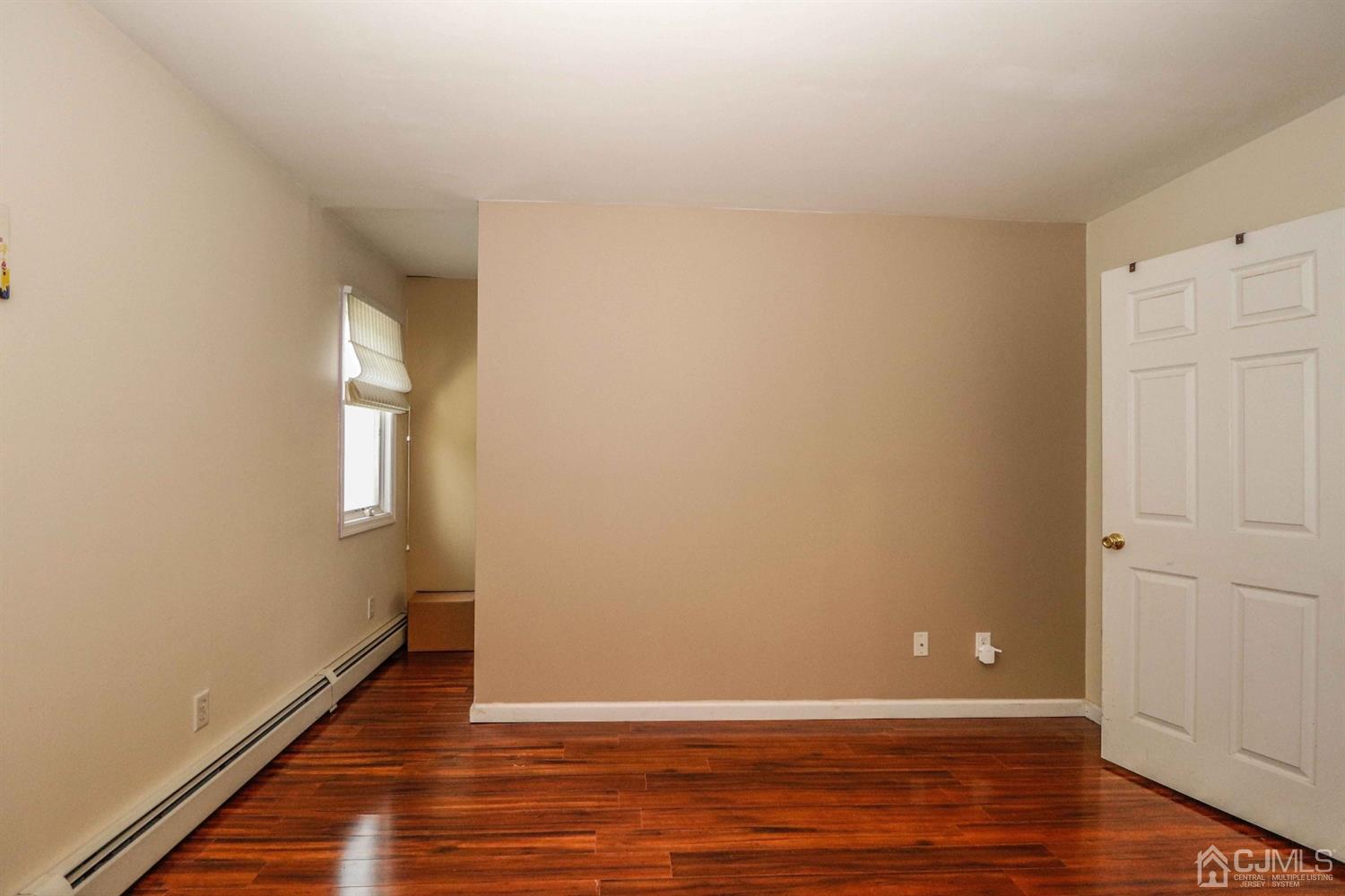 166 Brower Avenue Edison, NJ 08837 - Photo 22 of 48 a view of an empty room with wooden floor and a window