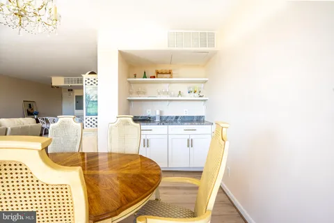 a living room with stainless steel appliances kitchen island granite countertop a sink and cabinets