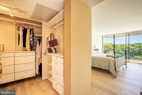 a view of walk in closet with clothes and shoes