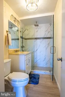 a bathroom with a granite countertop toilet sink and shower