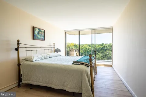 a bedroom with a bed and a large window