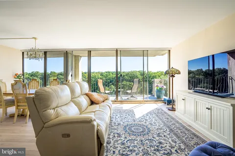 a living room with furniture and a floor to ceiling window