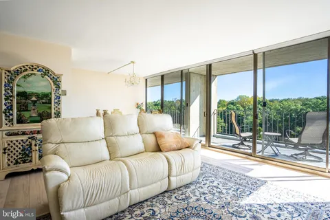 a living room with furniture and a floor to ceiling window
