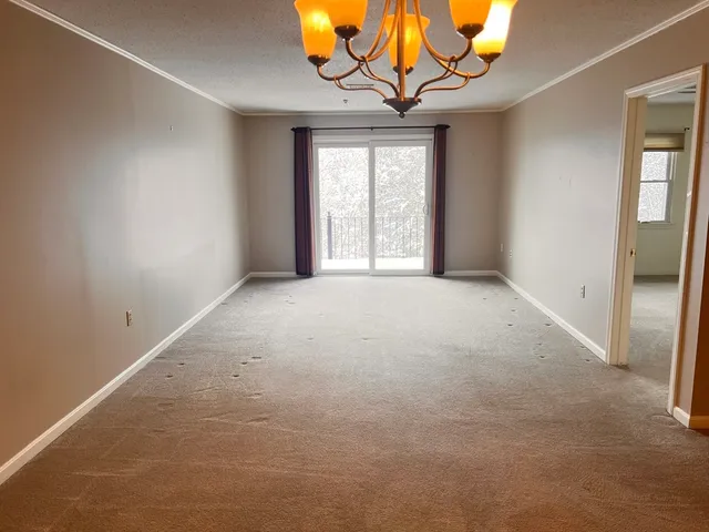 a view of a room with a large window and chandelier