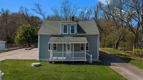 a view of a house with backyard and a tree