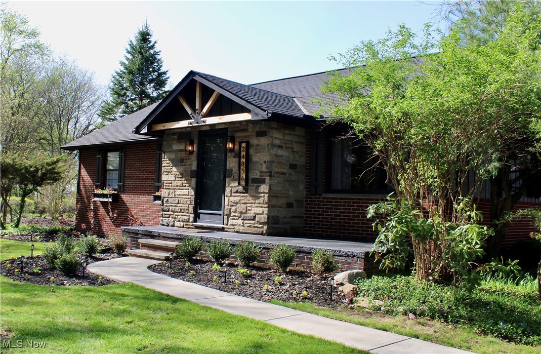 24836 Kennedy Ridge Road North Olmsted, OH 44070 - Photo 2 of 29 View of front of property featuring brick siding, roof with shingles, a front yard, and stone siding