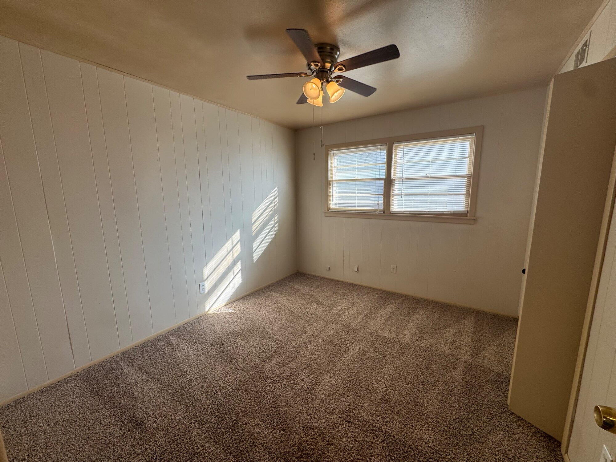 5230 14th Street Lubbock, TX 79416 - Photo 5 of 9 an empty room with windows and fan