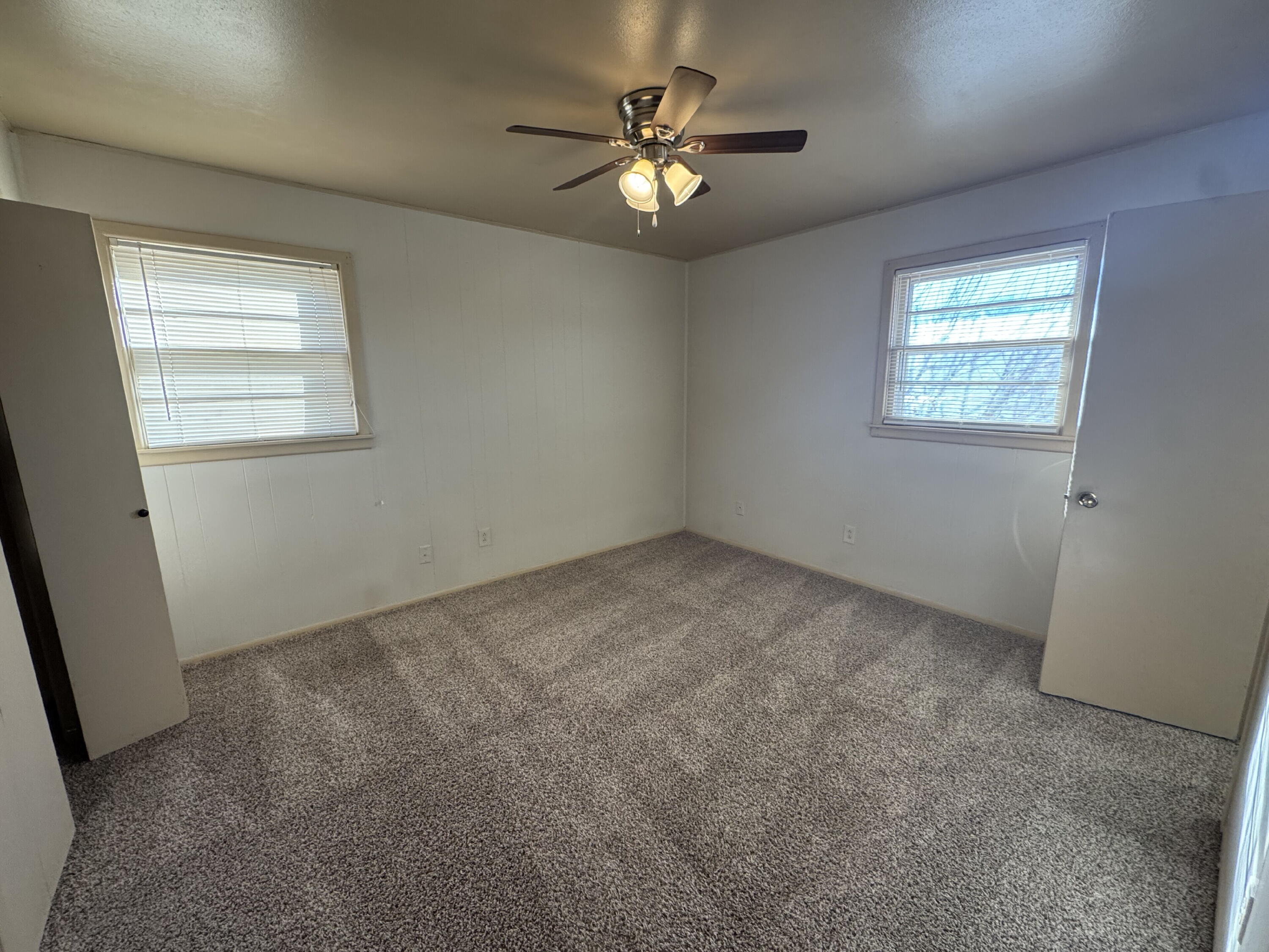 5230 14th Street Lubbock, TX 79416 - Photo 8 of 9 an empty room with windows and ceiling fan