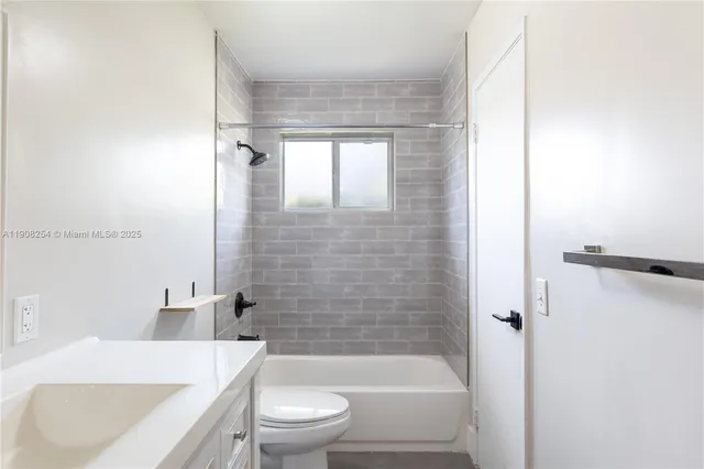 a bathroom with a bathtub shower sink vanity and toilet