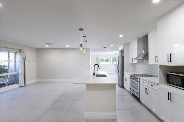 a large kitchen with kitchen island granite countertop a large counter top stainless steel appliances and cabinets