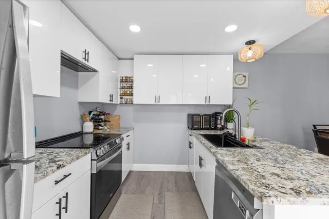 a kitchen with granite countertop a sink stove and cabinets